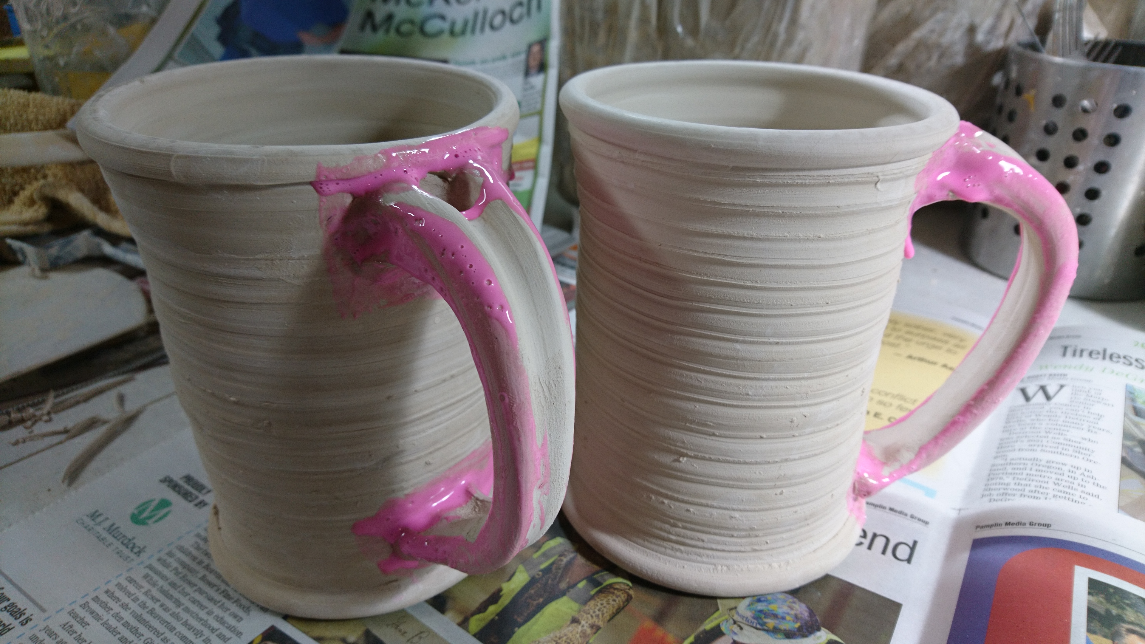 Photo of two mugs with pink wax on the handles