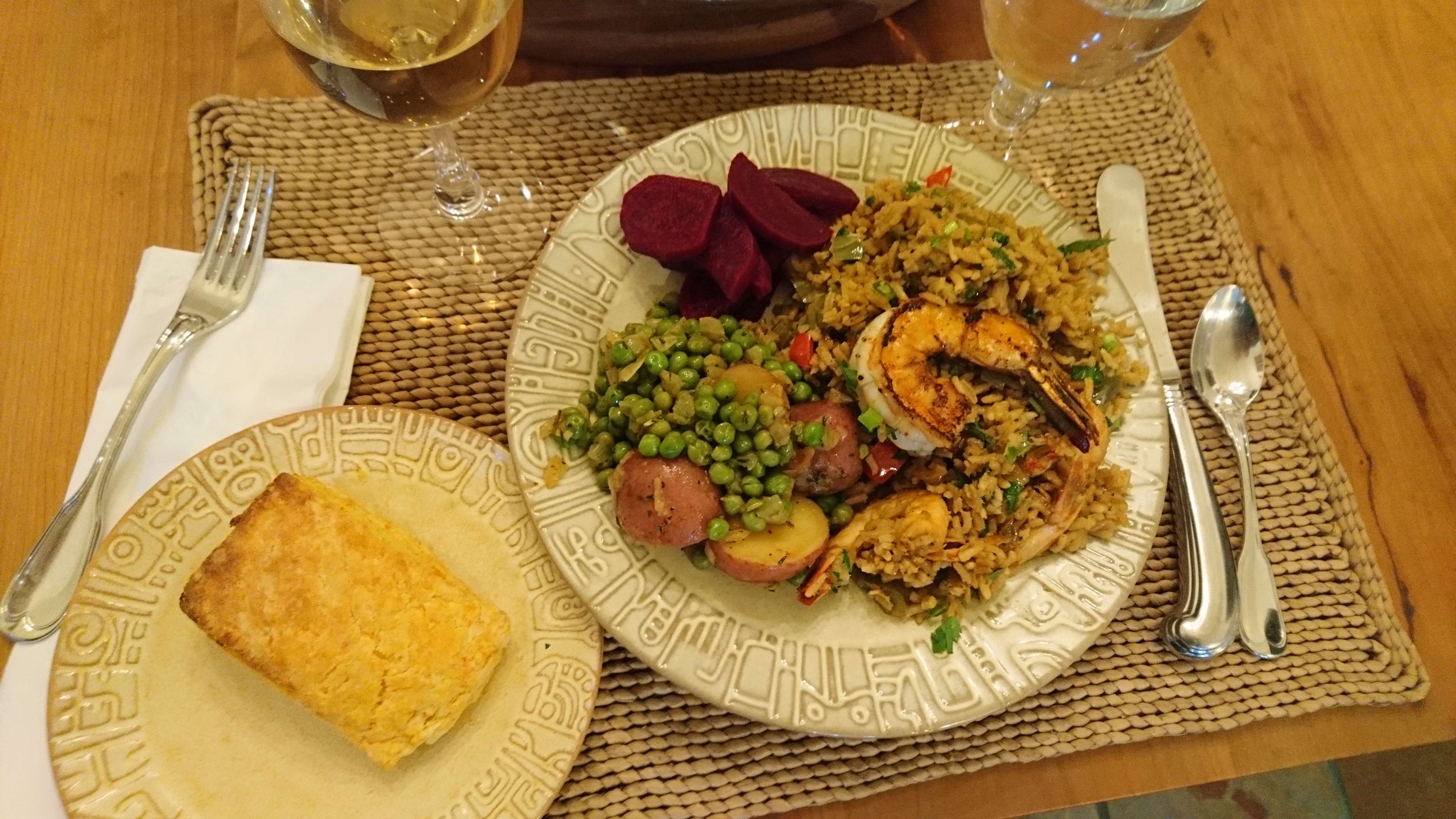 dinner setting with biscuit, jambalaya, peas, and beets