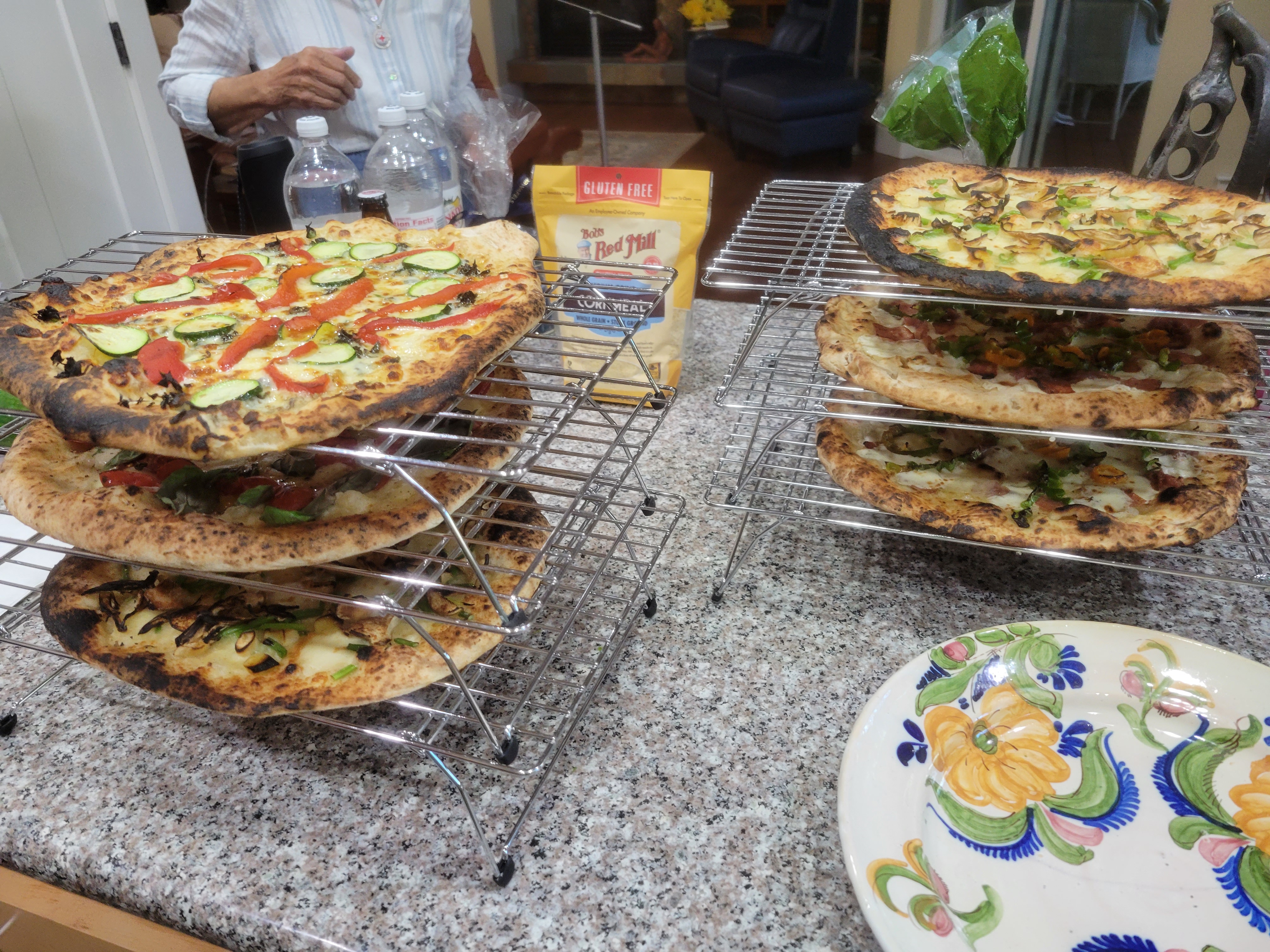 six pizzas, stacked on portable cake layer racks