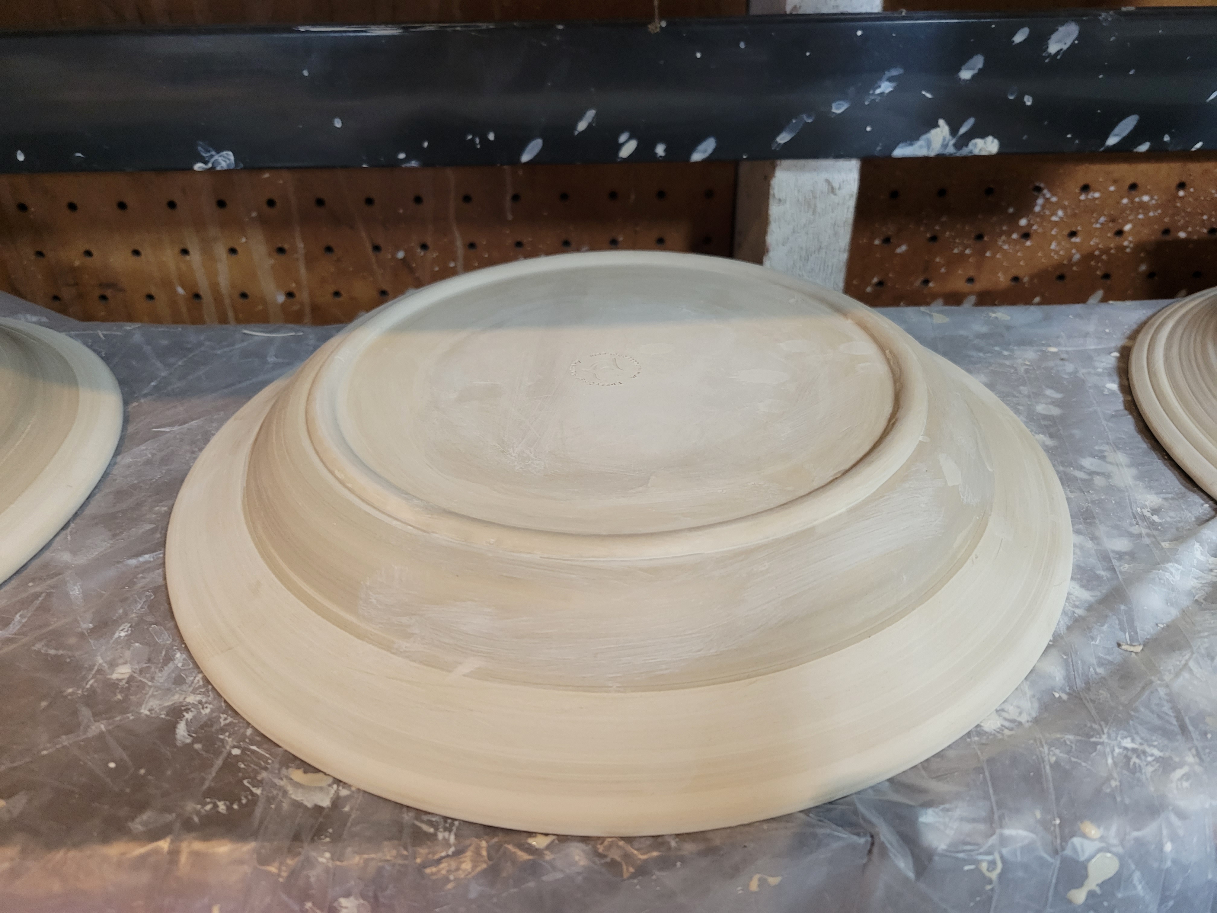 photo of a shallow bowl, drying upside down, showing off the plaster-formed foot