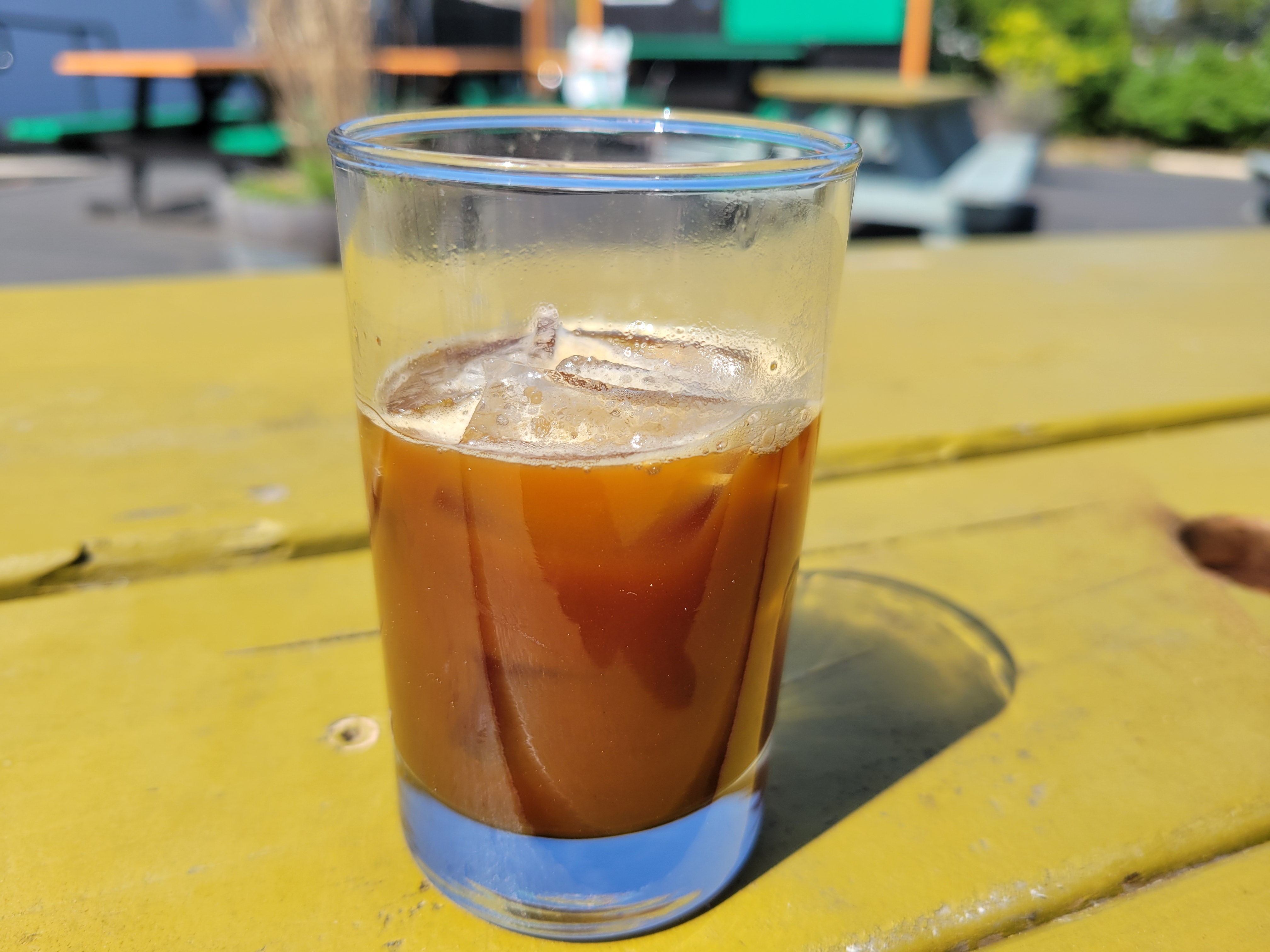 a shakerato in a glass, on a table in the sun