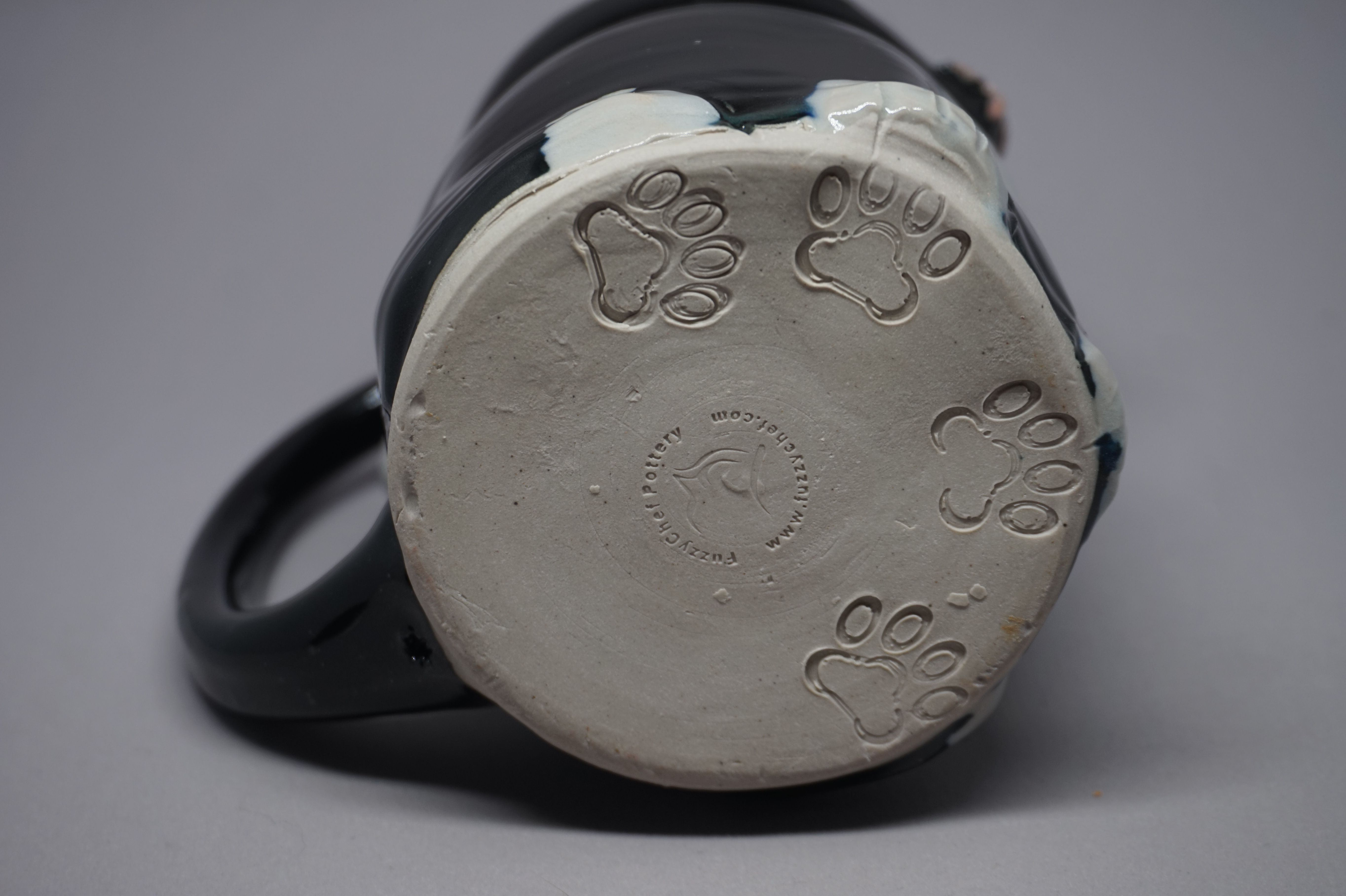 photo of the bottom of a cat mug, showing stamped foot designs