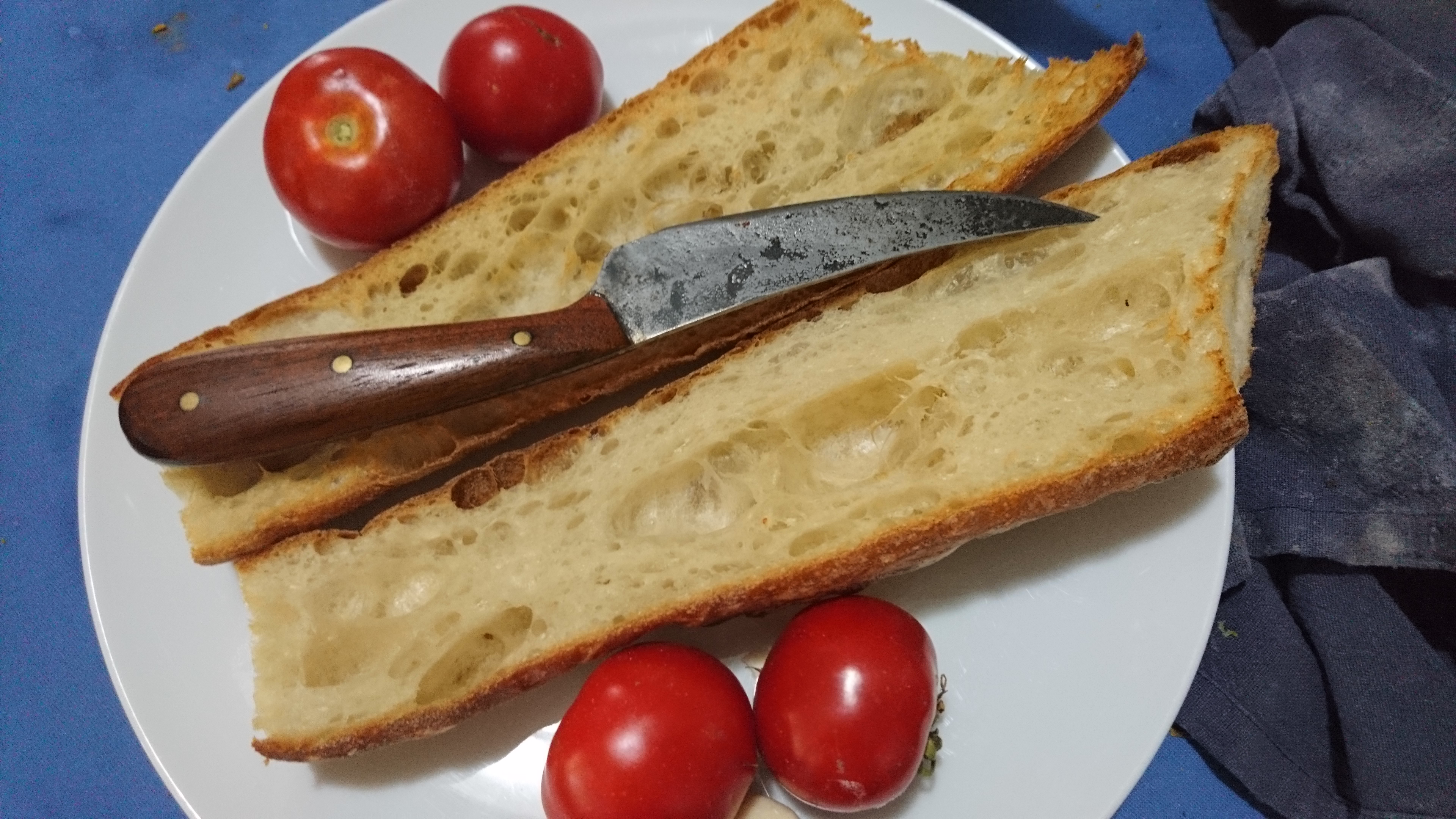 plate with tomatoes, bread, an half garlic cloves