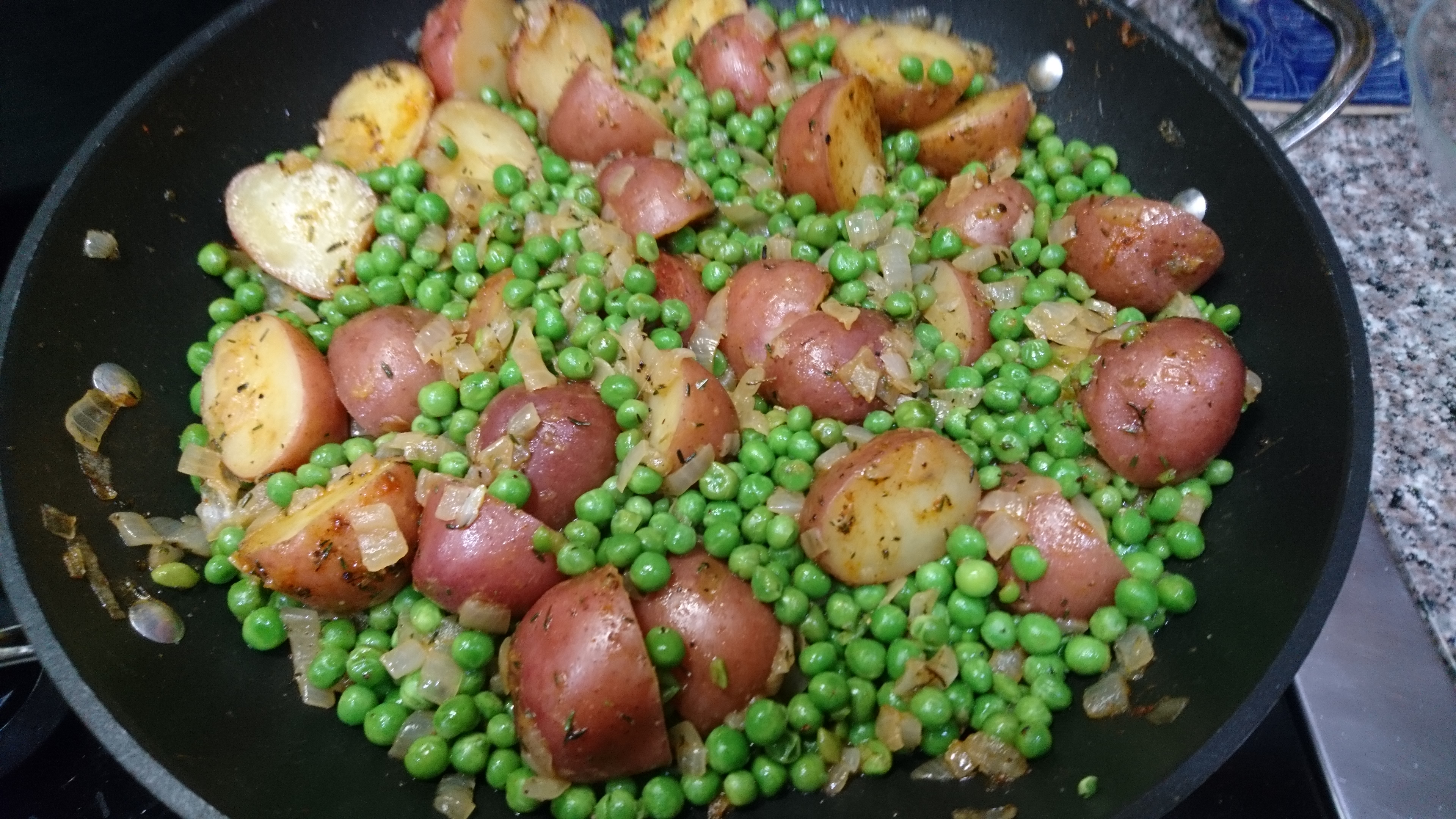 pan full of peas and potatoes