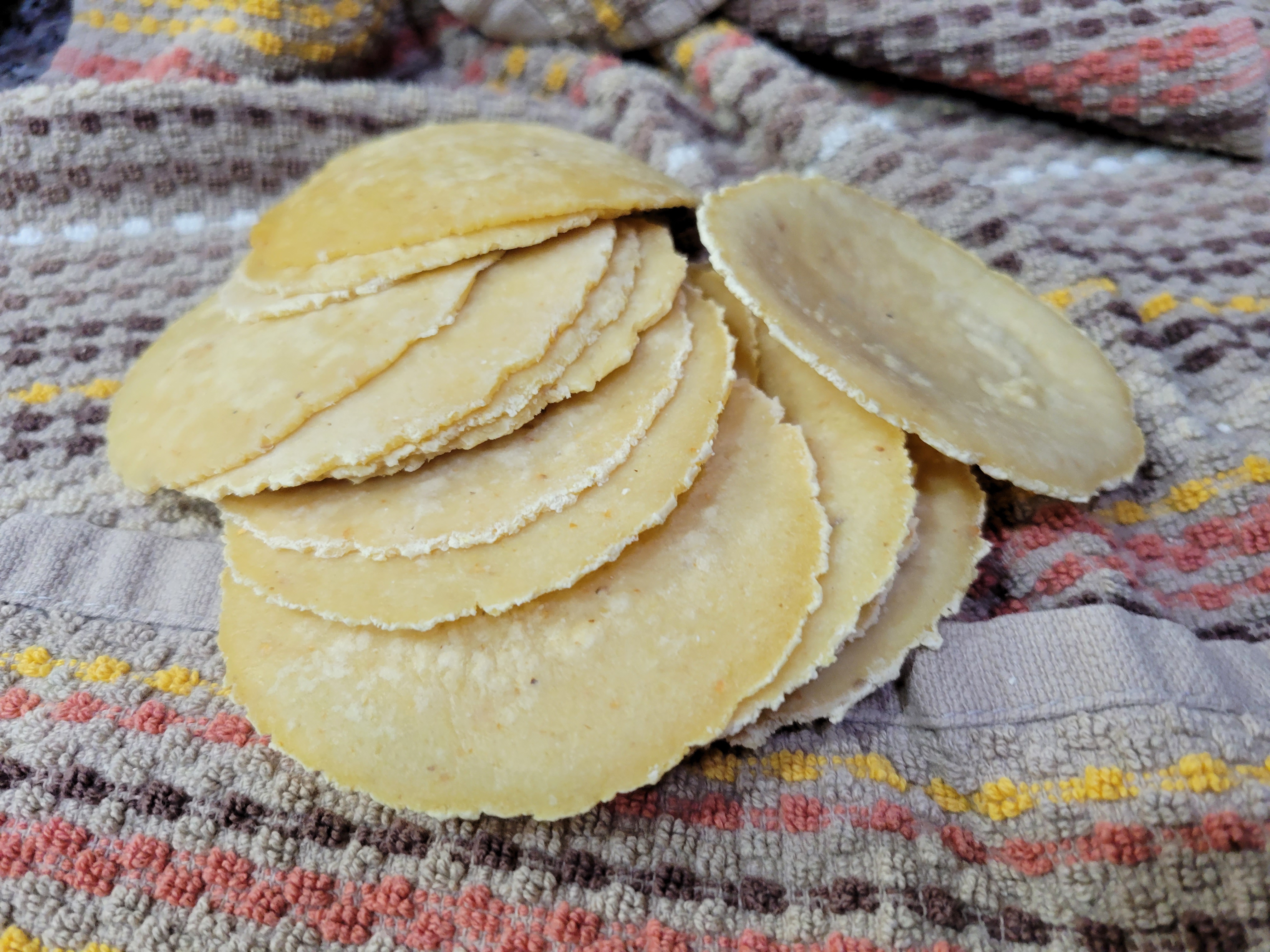 a dozen or so handmade mini-tortillas on a towel