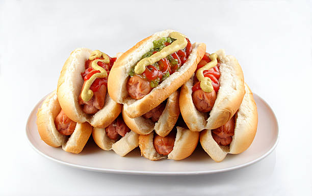 photo of a pile of hot dogs, with mustard
